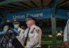 NYPD officers speak at Union Square station podium.