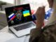 Laptop displaying ATTACK with Russian and Ukrainian flags