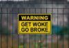 Warning sign Get Woke Go Broke on fence