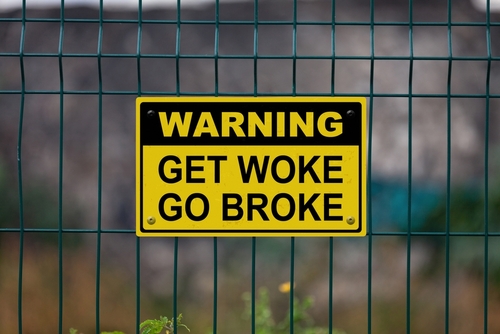 Warning sign Get Woke Go Broke on fence