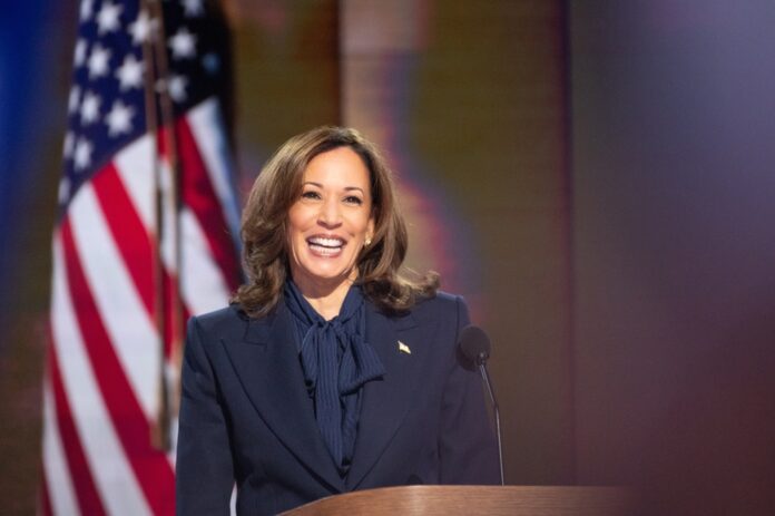 Person smiling at podium with American flag background