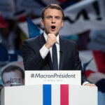 Emmanuel Macron at a campaign rally podium.