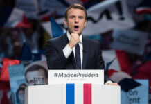 Emmanuel Macron at a campaign rally podium.