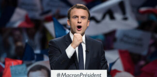 Emmanuel Macron at a campaign rally podium.