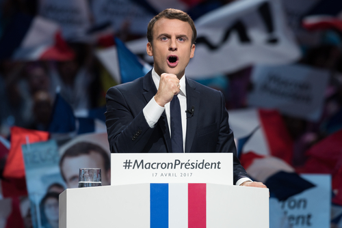 Emmanuel Macron at a campaign rally podium.