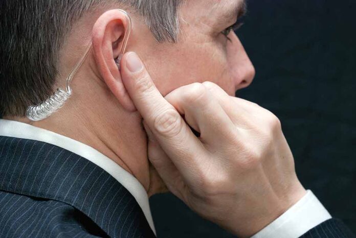 Man with earpiece listening intently.