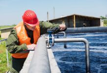 Worker inspecting water treatment plant pipes.