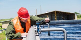 Worker inspecting water treatment plant pipes.