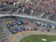 NASCAR race at Daytona Speedway with cheering spectators.