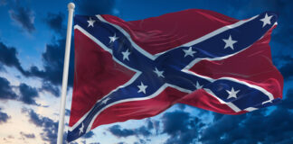 Confederate flag waving against a dramatic, cloudy sky.