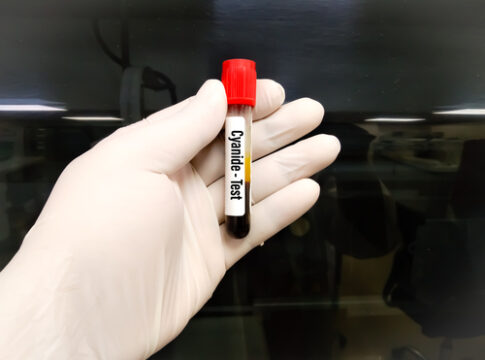 Hand holding cyanide test vial.