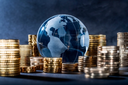 Glass globe surrounded by stacks of gold coins.