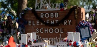 Memorial site at Robb Elementary School with floral tributes.