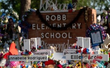 Memorial site at Robb Elementary School with floral tributes.