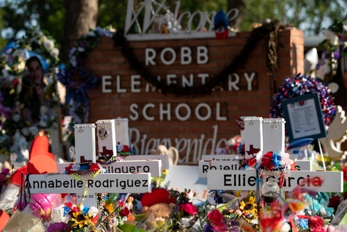 Memorial site at Robb Elementary School with floral tributes.