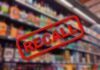 Recall sign over blurred grocery store shelves.