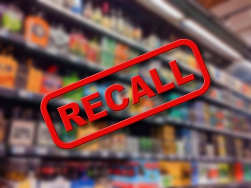 Recall sign over blurred grocery store shelves.