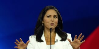 Person speaking at a podium with hands raised