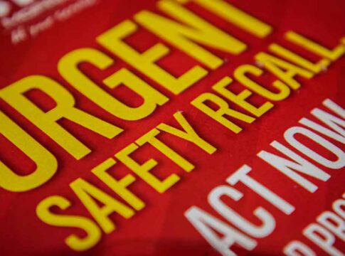 Urgent Safety Recall sign on red background.