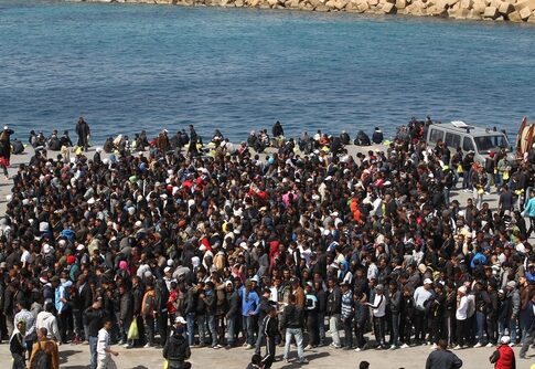 Large crowd gathered near a waterfront.