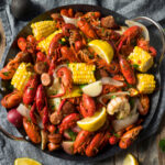 A vibrant seafood platter featuring crawfish, corn, and sausage