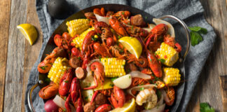 A vibrant seafood platter featuring crawfish, corn, and sausage