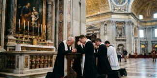 Clergy members kneeling in prayer inside a grand cathedral