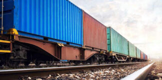 Train with colorful cargo containers on railway track.
