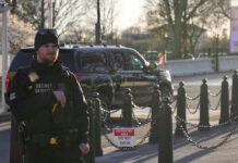 Secret Service agent standing near restricted area sign.