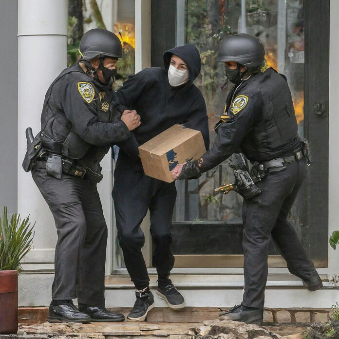 2475048503 Police arresting person holding a box.