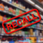 Recall sign over blurred grocery store shelves