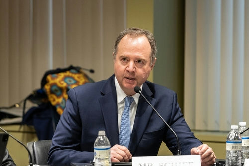 A man in a suit speaking into a microphone.