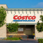 Costco Wholesale storefront with trees and empty shopping carts.