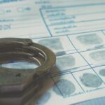Handcuffs resting on a fingerprint card with inked fingerprints