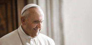Pope Francis smiling in a white robe and zucchetto