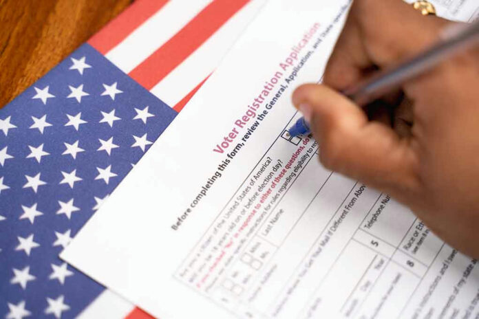 1762483943 Person filling out voter registration form, American flag background.