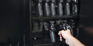 Hand reaching into a gun safe to pick up a handgun