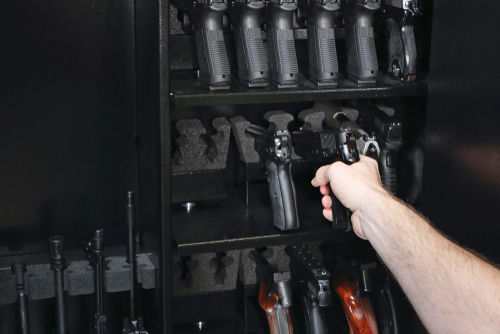 shutterstock1136777828jpg Hand reaching into a gun safe to pick up a handgun