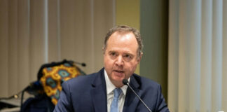 A man in a suit speaking into a microphone.