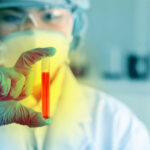 Airport Bust Exposes Bio-Lab Gaps Scientist holding a test tube with red liquid in a laboratory setting