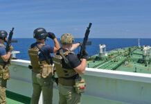 British Commandos Rappelled Onto a Tanker at Night — In the English Channel Armed security team on a ship deck overlooking a large tanker at sea