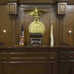 Top Court Hammers Powerful Church Judges bench in an empty courtroom, scales emblem above.