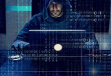 Phone Fraud Kingpins Just Hit a Wall Person in hoodie using a laptop with binary code overlay