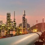 Drone Barrage Rattles Saudi Crown Jewel Oil refinery with pipelines at sunset