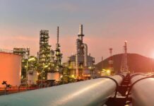 Oil refinery with pipelines at sunset