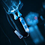 Close-up of an IV drip setup with a blue background