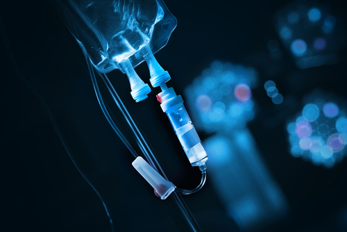 Close-up of an IV drip setup with a blue background