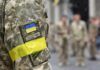 Soldier in camouflage with Ukrainian flag patch and yellow armband