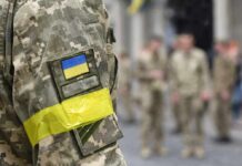 Soldier in camouflage with Ukrainian flag patch and yellow armband