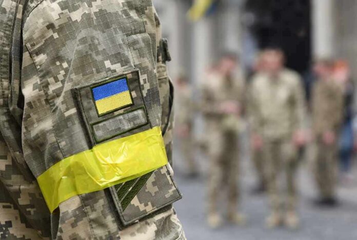 Soldier in camouflage with Ukrainian flag patch and yellow armband